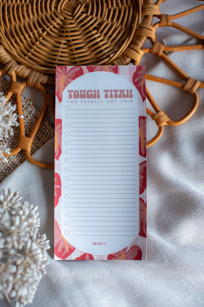 Notepad with floral design on a textured surface with decorative elements